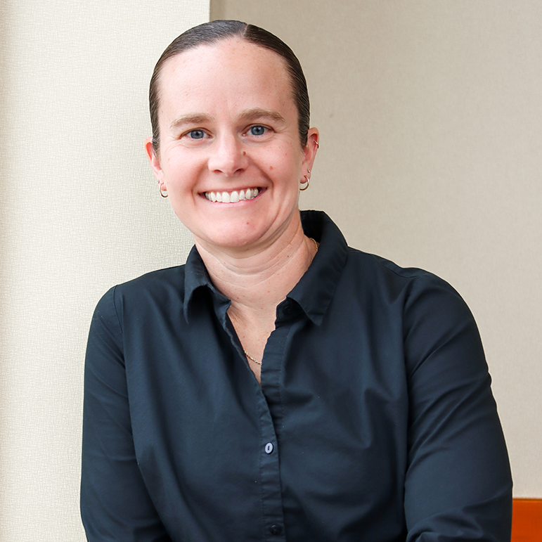 Headshot of Megan Pask, Vice President of Operations wearing a black button up smiling in front of a blank wall.